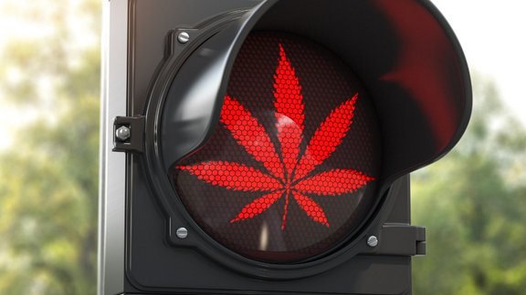 Eine rote Ampel mit Cannabis-Logo